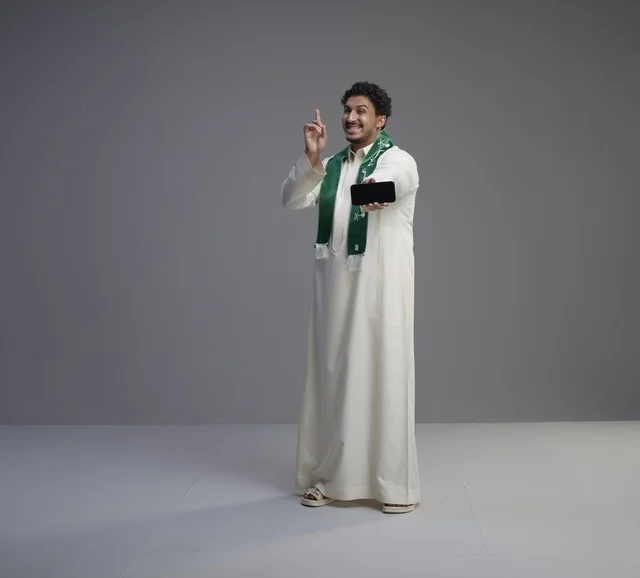 Saudi Man Holding Smartphone with Green Scarf