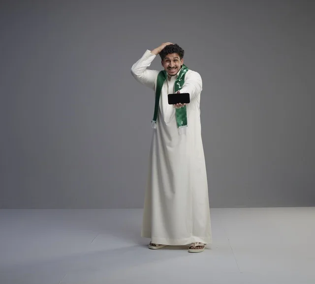 Saudi Man Holding Smartphone with Surprised Expression