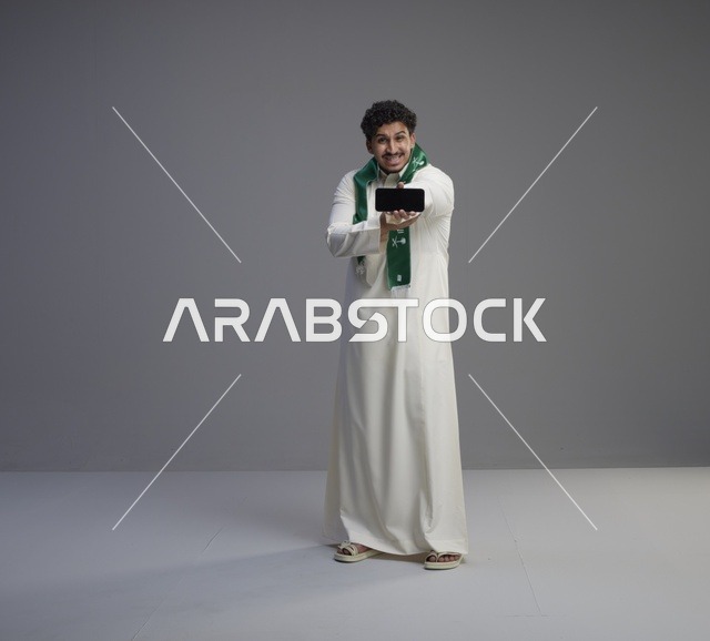 شاب سعودي يمسك هاتف ذكي بشاشة فارغة