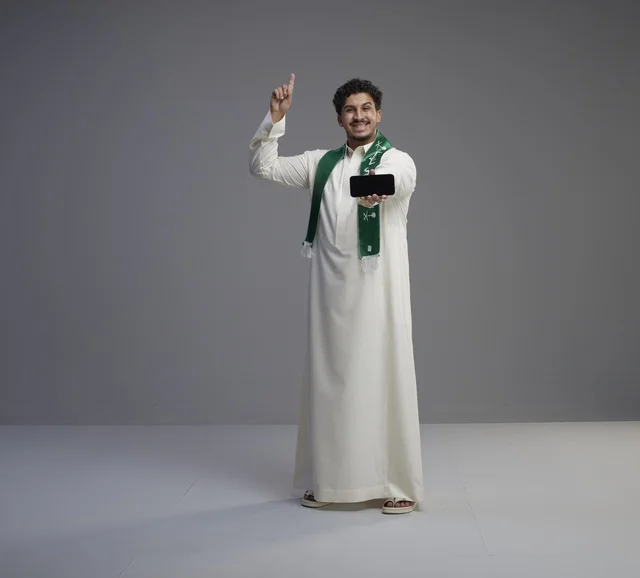 Saudi Man Holding Smartphone Screen and Pointing Up