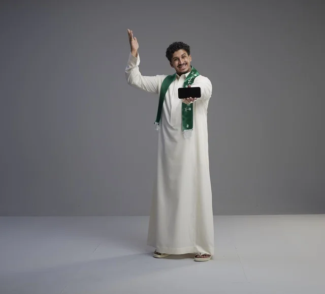 Saudi Man Holding Smartphone with Blank Screen