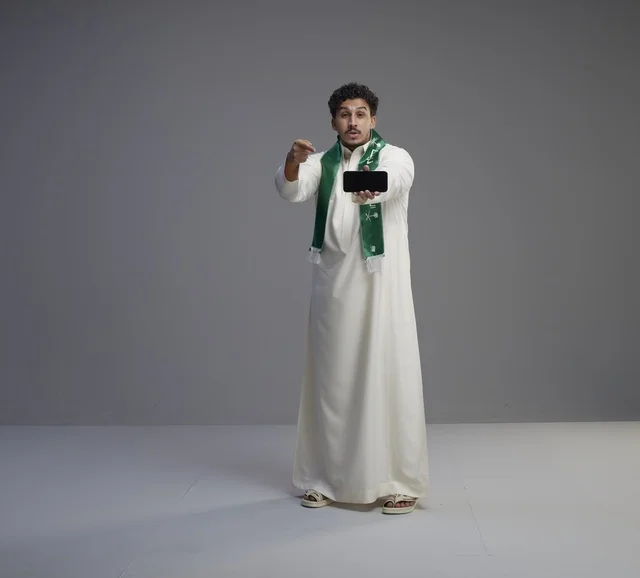 Saudi Man Holding Smartphone Screen in Studio