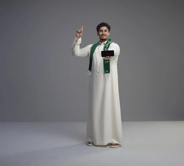 Saudi Man Holding Smartphone Screen in Studio