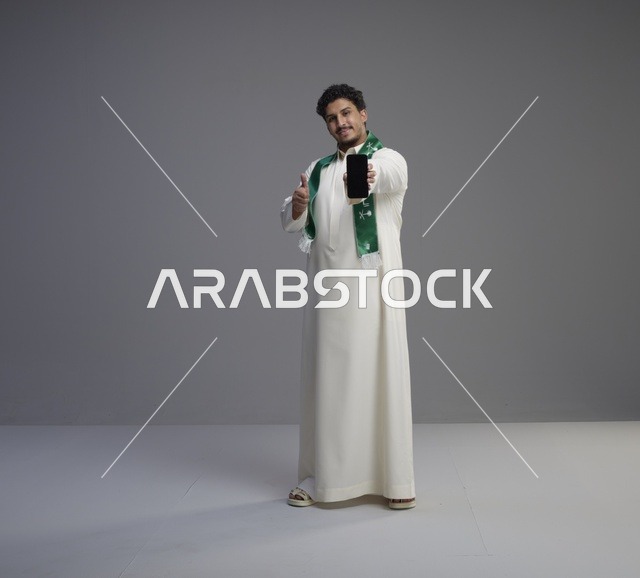 شاب سعودي يعرض شاشة هاتف ذكي في الاستوديو