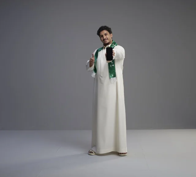 Saudi Man Holding Smartphone Screen in Studio
