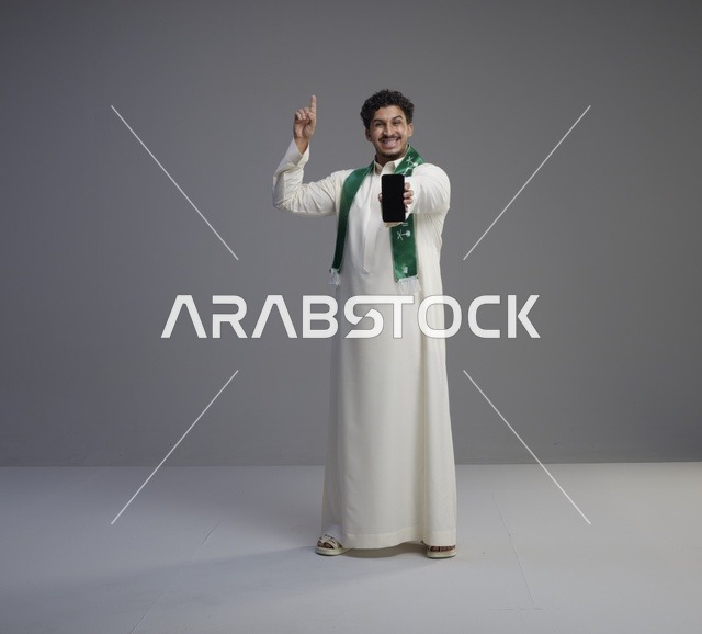 شاب سعودي يمسك هاتف ذكي بشاشة سوداء فارغة