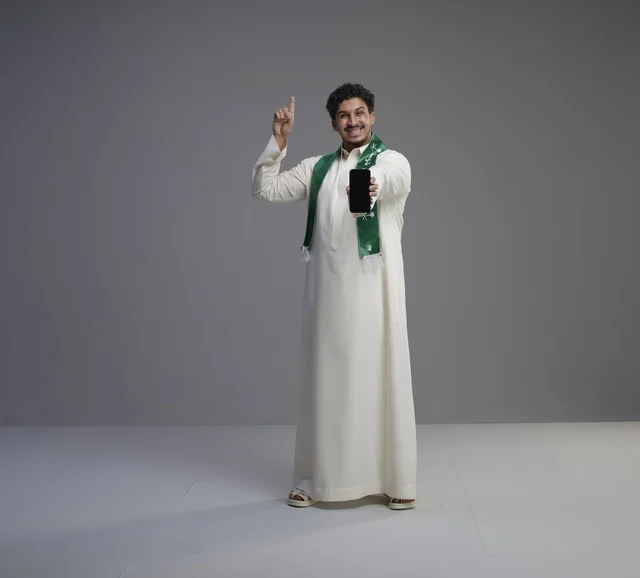 Saudi Man Holding Smartphone Screen in Studio