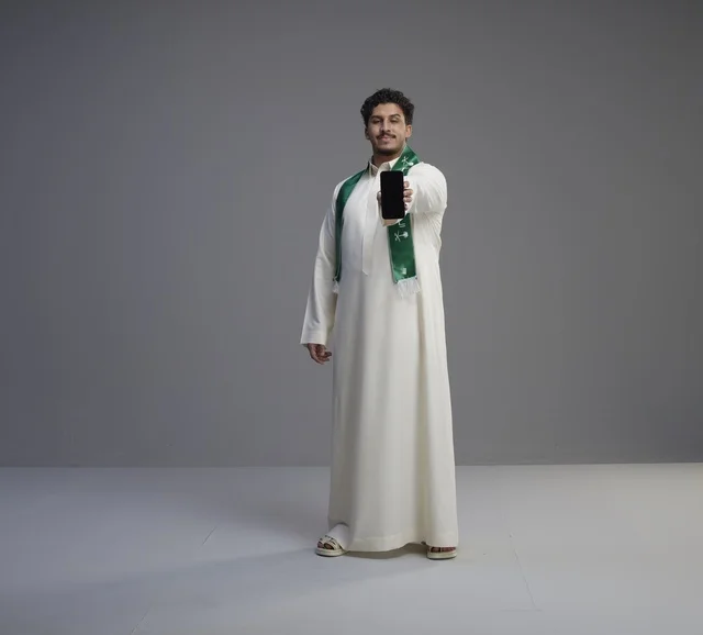 Saudi Man Holding Smartphone with Blank Screen
