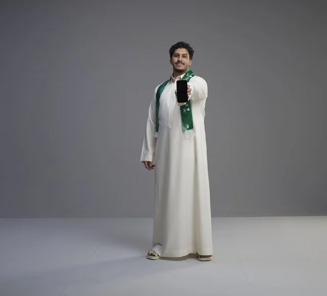 Saudi Man Holding Smartphone with Blank Screen