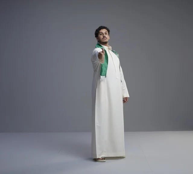Saudi Man in National Scarf Pointing at Camera