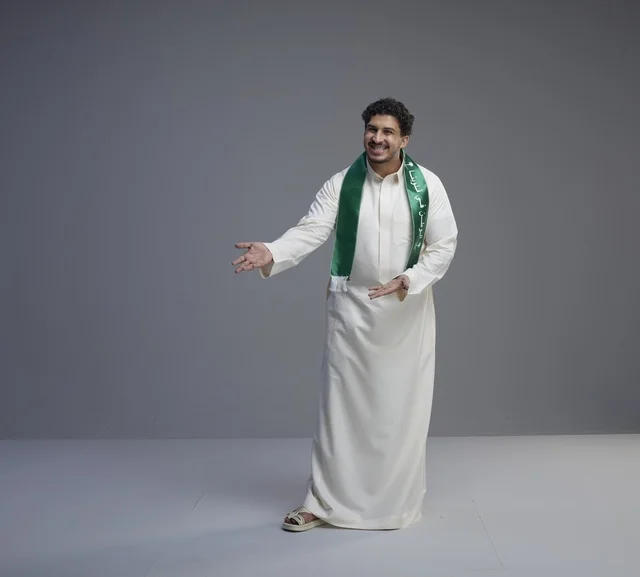 شاب سعودي يرتدي وشاح اليوم الوطني السعودي
