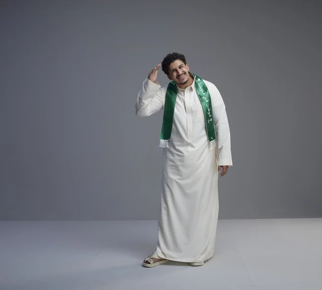 شاب سعودي بوشاح وطني يؤدي التحية العسكرية