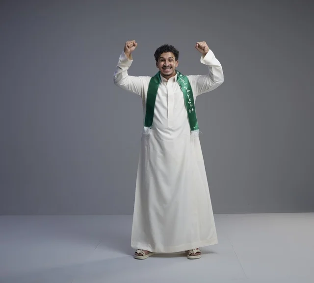شاب سعودي يحتفل بالوشاح الوطني السعودي والثوب الأبيض