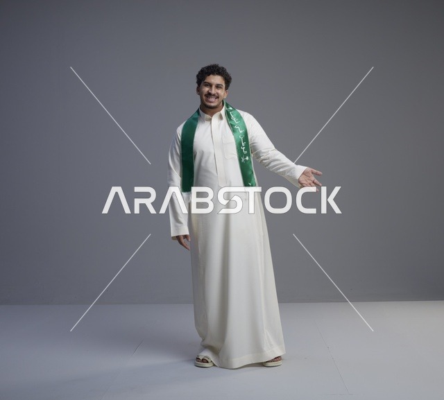 شاب سعودي بالثوب والوشاح الوطني في الاستوديو