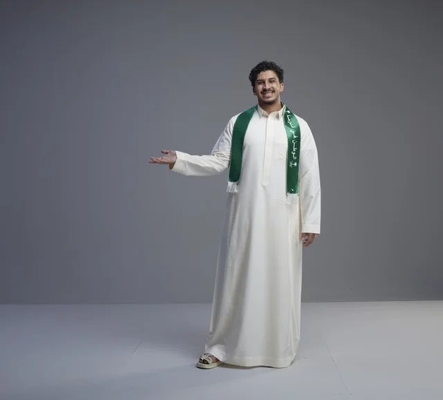 شاب سعودي بالوشاح الوطني يشير بيده في الاستوديو شاب سعودي بالوشاح الوطني يشير بيده في الاستوديو