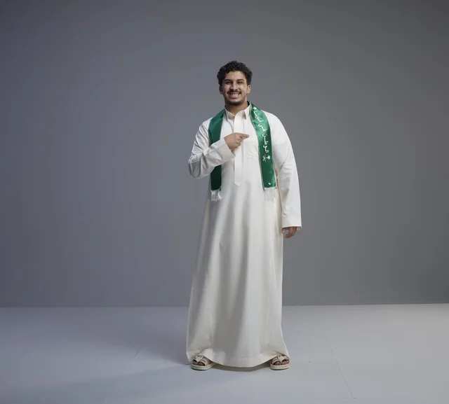 Saudi Man in National Scarf on Grey Background