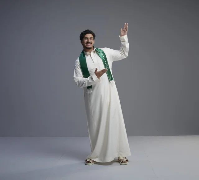 شاب سعودي يرتدي الوشاح الوطني في استوديو