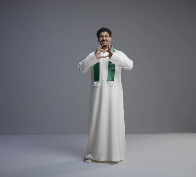 Saudi Man with National Scarf Making Heart Gesture