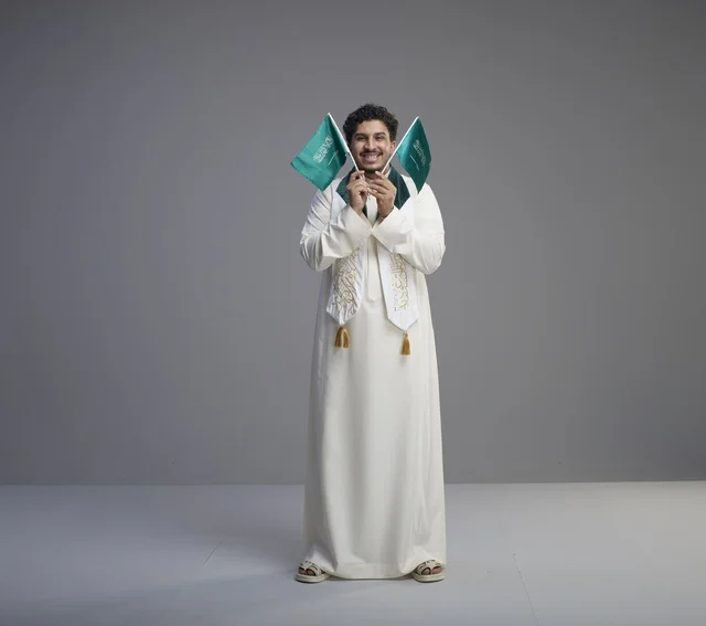 Saudi Graduate Man Holding National Flags in Studio