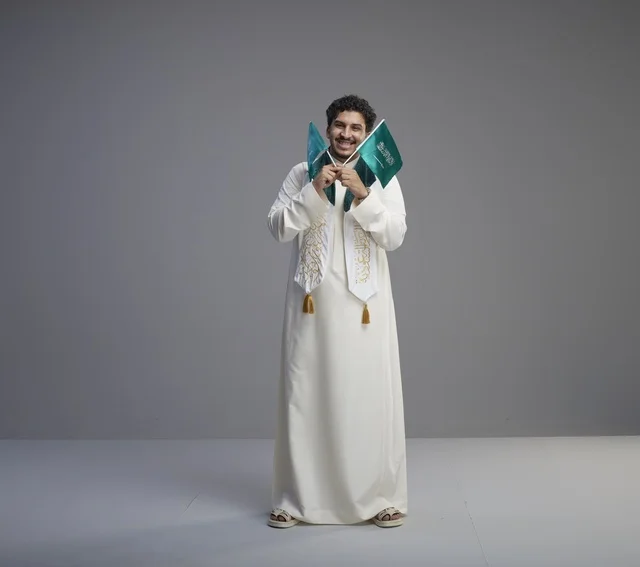 خريج سعودي يحتفل بالعلم الوطني في الاستوديو