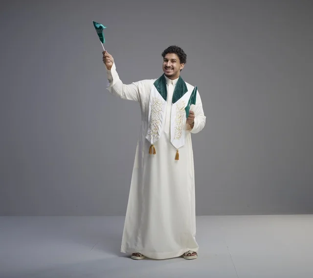 Saudi Graduate Celebrating with National Flag in Studio