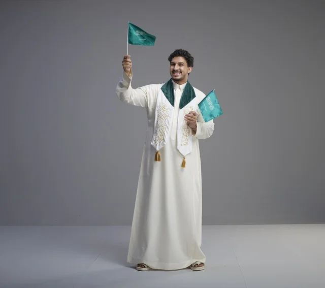 Saudi Graduate Holding National Flags in Studio