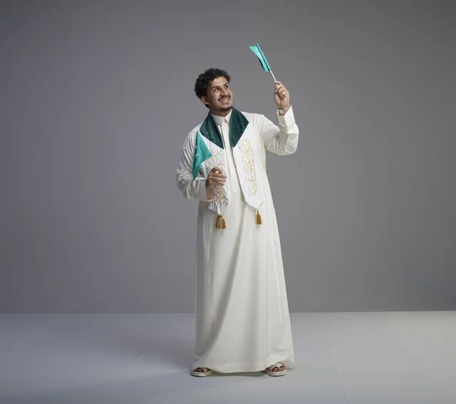 Saudi Graduate Holding National Flags in Studio