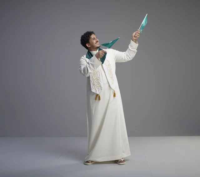 Saudi Male Graduate Holding National Flags in Studio