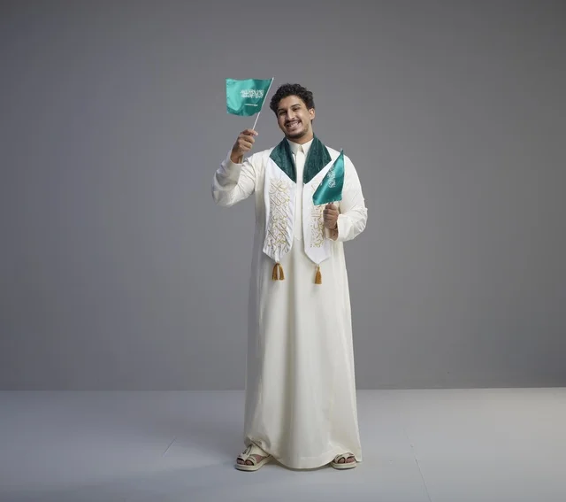 Saudi Graduate Holding National Flag in Studio