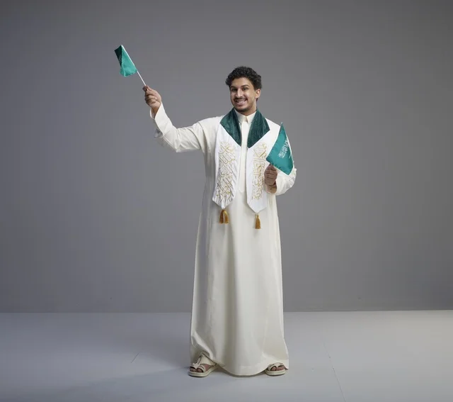 Saudi Graduate Holding National Flags in Studio Setting