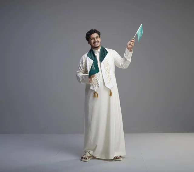 Saudi Graduate Holding National Flag in Studio Portrait