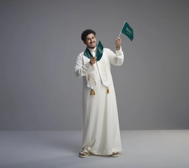 خريج سعودي يحتفل بالعلم الوطني في الاستوديو