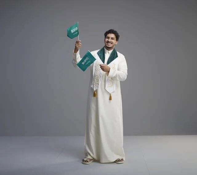 Saudi Male Graduate Holding National Flags in Studio Saudi Male Graduate Holding National Flags in Studio