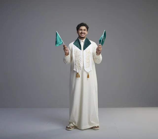 Saudi Graduate Holding National Flag in Thobe