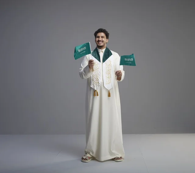 Saudi Graduate Holding National Flags in Grey Studio