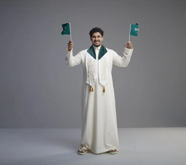Saudi Graduate Holding National Flags in Studio
