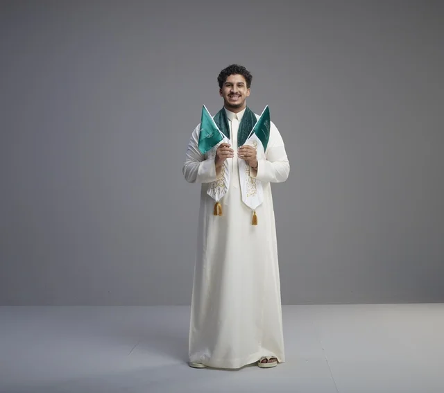 خريج سعودي مبتسم يحمل أعلام المملكة العربية السعودية خريج سعودي مبتسم يحمل أعلام المملكة العربية السعودية