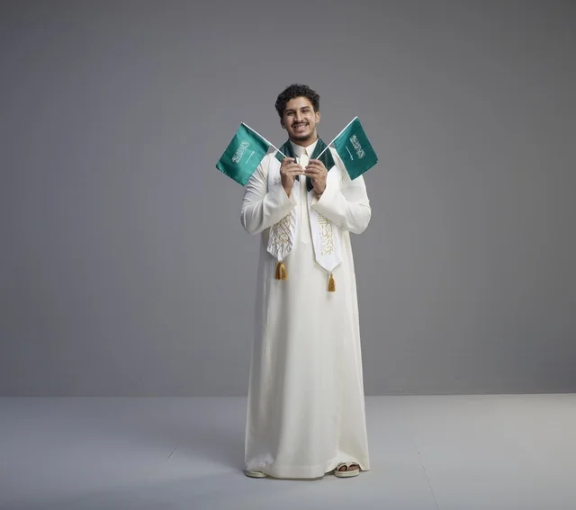 خريج سعودي يحمل الأعلام الوطنية في الاستوديو خريج سعودي يحمل الأعلام الوطنية في الاستوديو