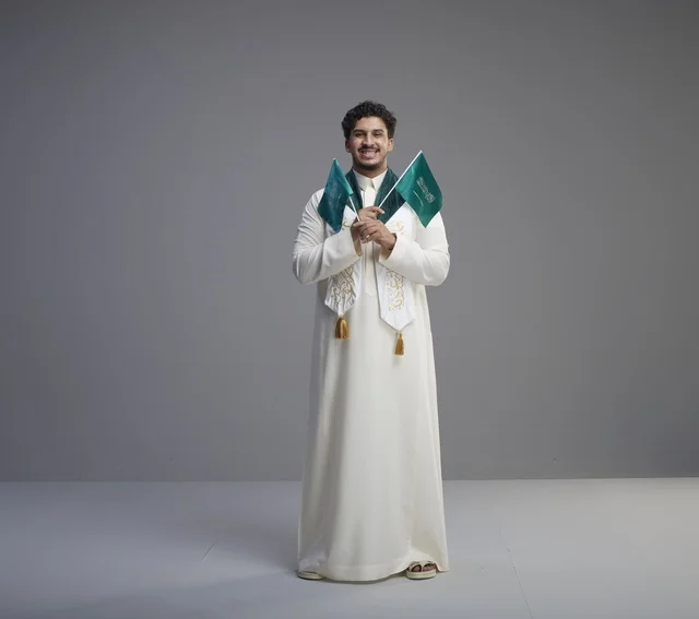 Saudi Graduate Holding National Flags in Studio
