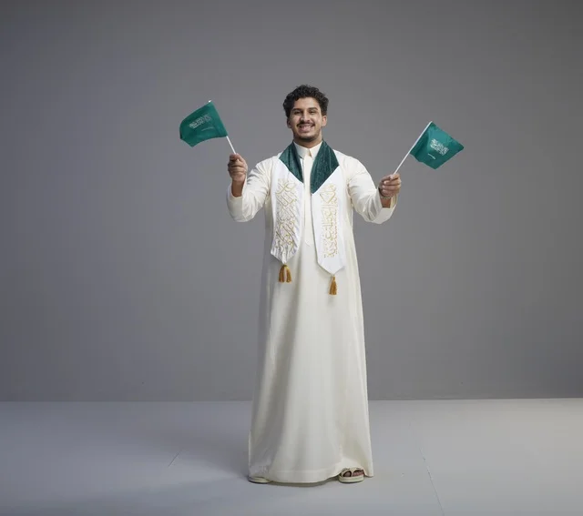 Saudi Graduate Holding National Flags in Studio