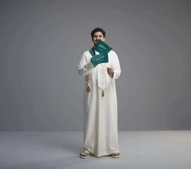 خريج سعودي يحمل العلم الوطني للاحتفال