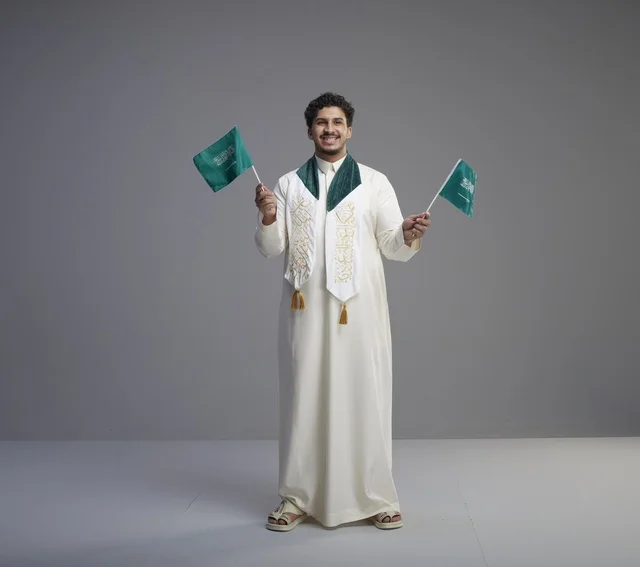 Saudi Male Graduate Holding National Flags in Studio