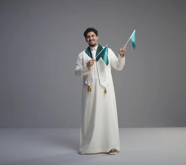 Saudi Graduate Holding National Flags in Studio