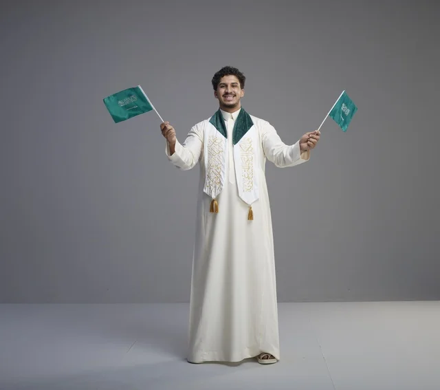 Saudi Male Graduate Holding National Flags in Studio