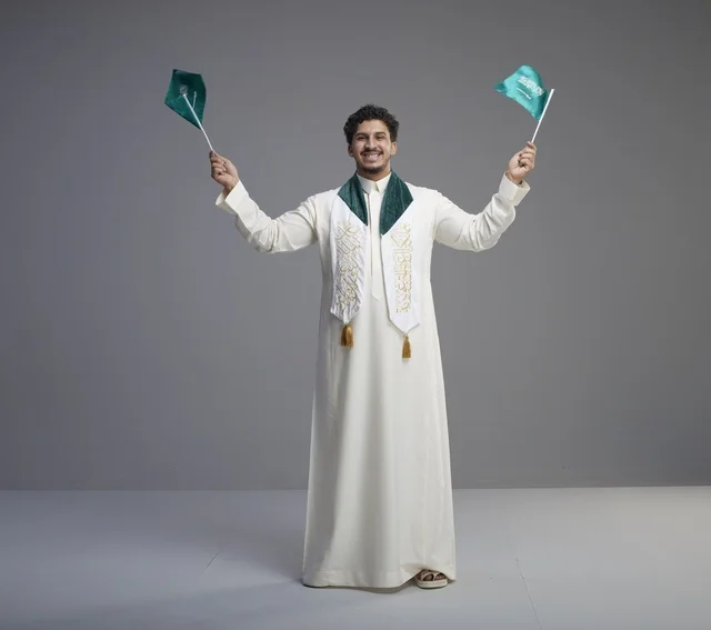 Saudi Graduate Celebrating with National Flags in Studio