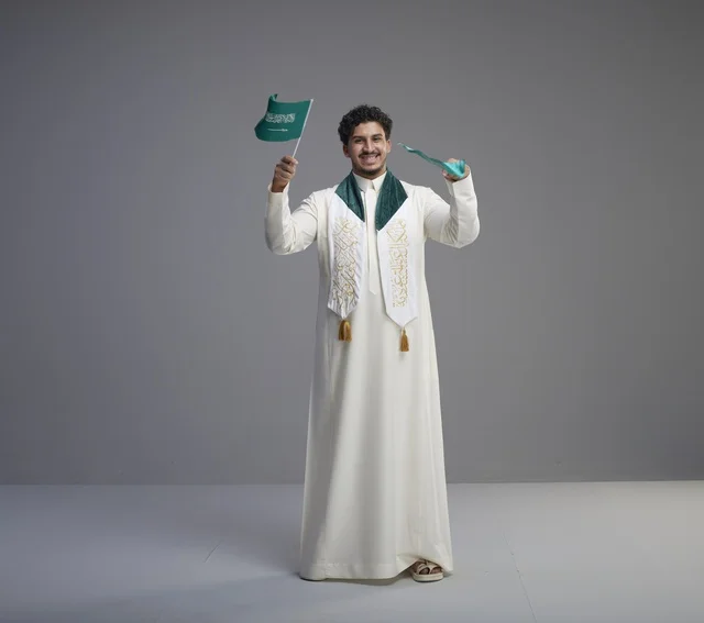 خريج سعودي يحتفل بالعلم الوطني في الاستوديو