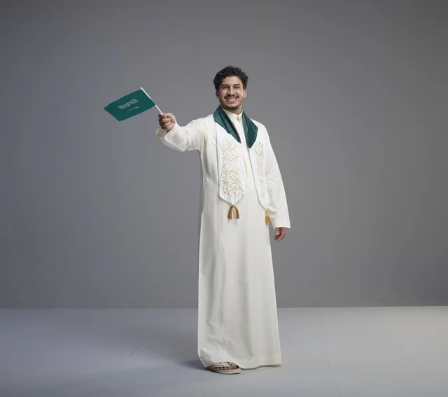 Saudi Graduate Holding National Flag in Studio Background
