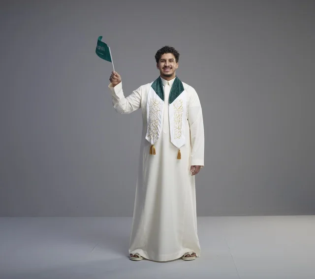 Saudi Graduate Holding National Flag in Studio