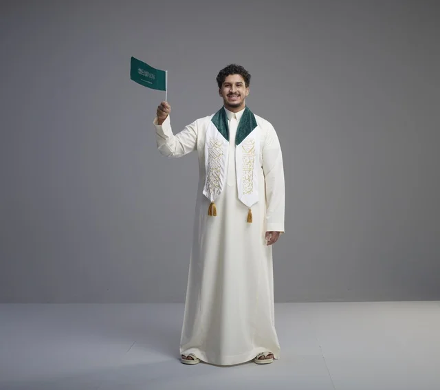 Saudi Graduate Holding National Flag in Studio