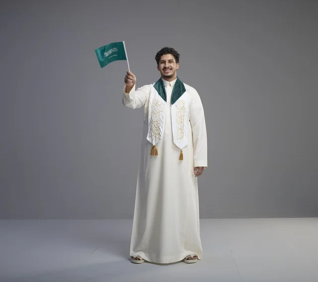 خريج سعودي يحمل العلم الوطني في استوديو
